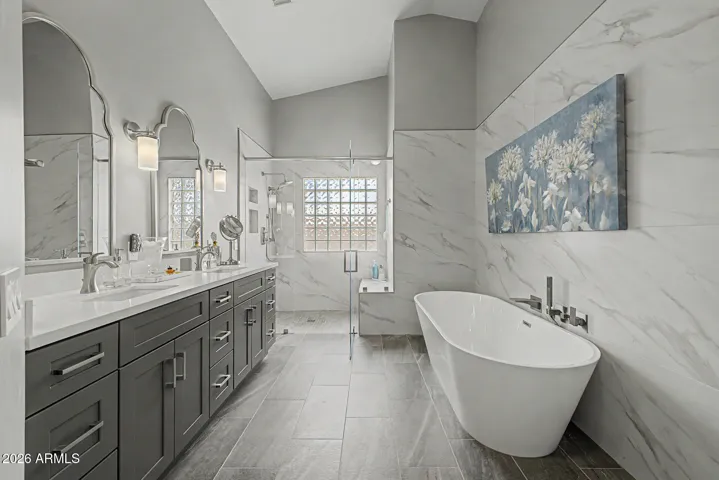 Spa-like primary bath with freestanding soaking tub and walk-in glass shower.