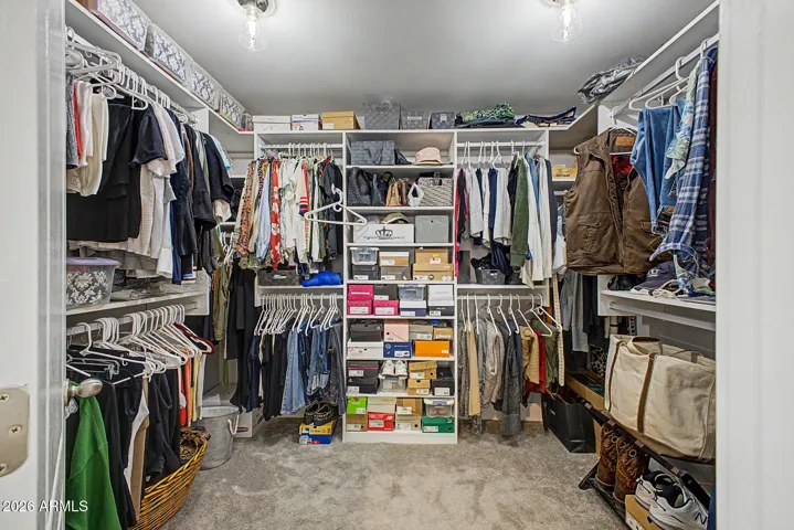 Spacious walk-in closet with California Closets custom designed storage system.