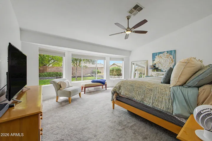 Spacious primary suite with vaulted ceilings, plush carpeting and abundant natural light.