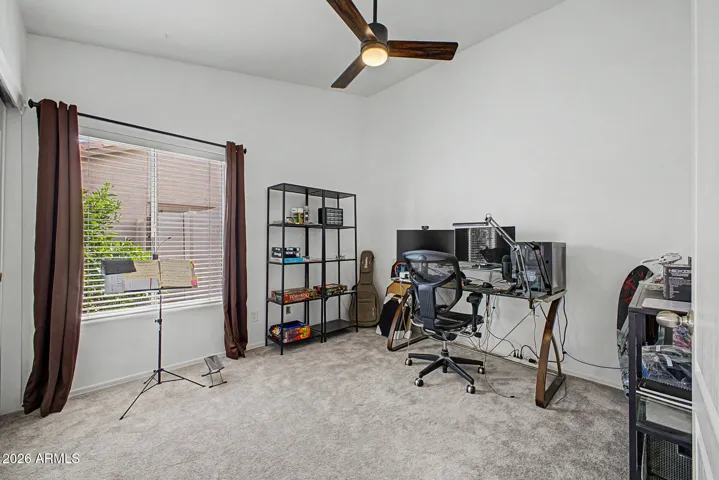 Versatile fourth bedroom currently set up as a home office, featuring newer carpet, ceiling fan, and plenty of room for work or hobbies.