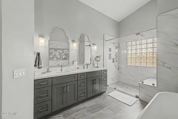 Dual sink vanity with custom cabinetry and stylish designer mirrors.