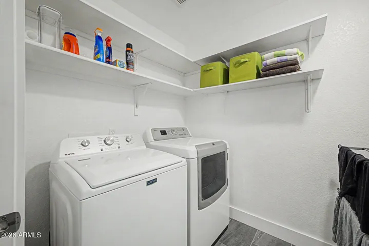 Private laundry room with built-in shelving for organized storage and additional space for a vacuum or household essentials.