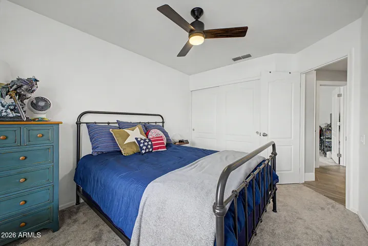 Cozy bedroom with newer carpet, ceiling fan, and a comfortable layout that feels warm and inviting.