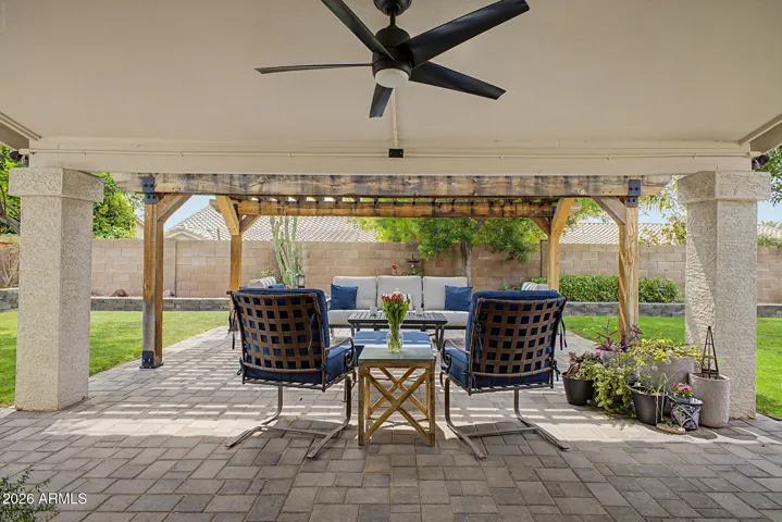 Extended paver patio with custom pergola, creating a shaded outdoor living space complete with ceiling fan for year-round comfort.