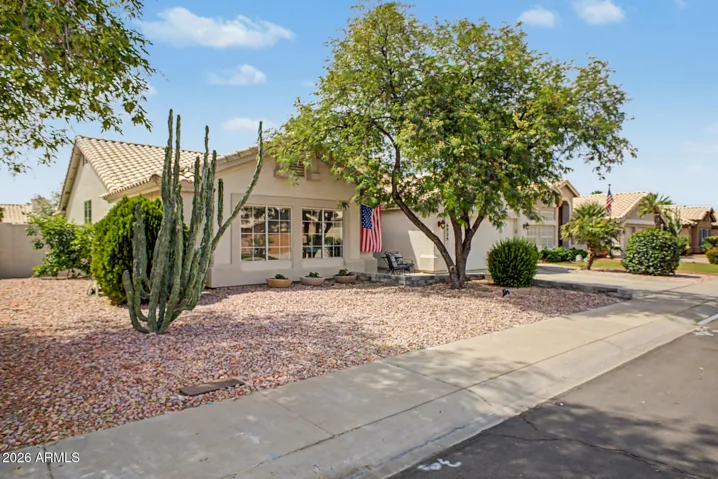 Inviting front exterior with shaded seating area and charming details.
