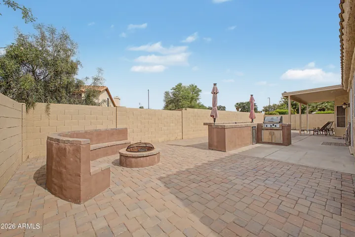 Back Yard View of Outdoor Kitchen and Firepit with Seating