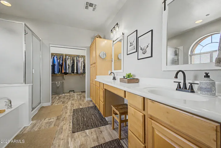 Primary suite includes a spacious walk in closet with built in shelving.