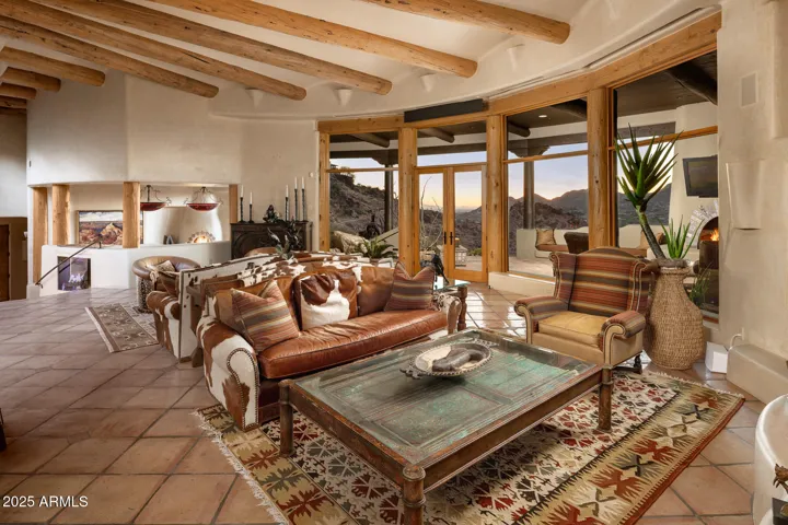 Floor-to-ceiling windows flood this stunning great room with natural light, revealing expansive Paradise Valley and mountain vistas. The open living space flows seamlessly into the outdoors for effortless entertaining and year-round enjoyment.