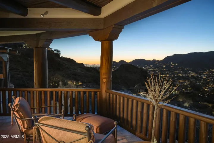 Enjoy breathtaking mountain and city light views from the primary suite's private patio. This covered outdoor space offers a peaceful setting to take in Arizona sunsets while nestled in the hills of prestigious Paradise Valley.