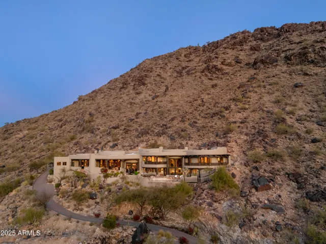Discover an exceptional residence tucked within one of Paradise Valley’s most prestigious gated communities. Carved directly into the mountainside, this custom-built estate features multiple terraces, lush desert landscaping, and a discreet driveway that leads to a world of exclusive privacy and luxury.