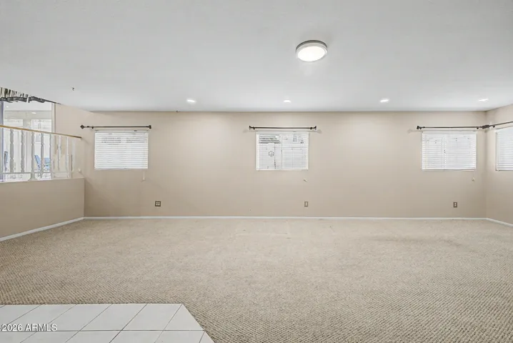 Spacious family room/recreation room with multiple windows, open layout, and versatile space ideal for gatherings or activities.