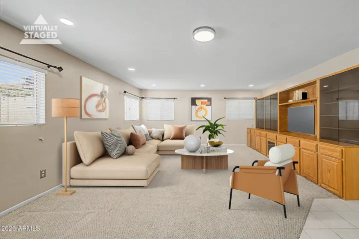 Large family room with open layout and built-in cabinetry, virtually staged to illustrate comfortable seating and entertainment possibilities.