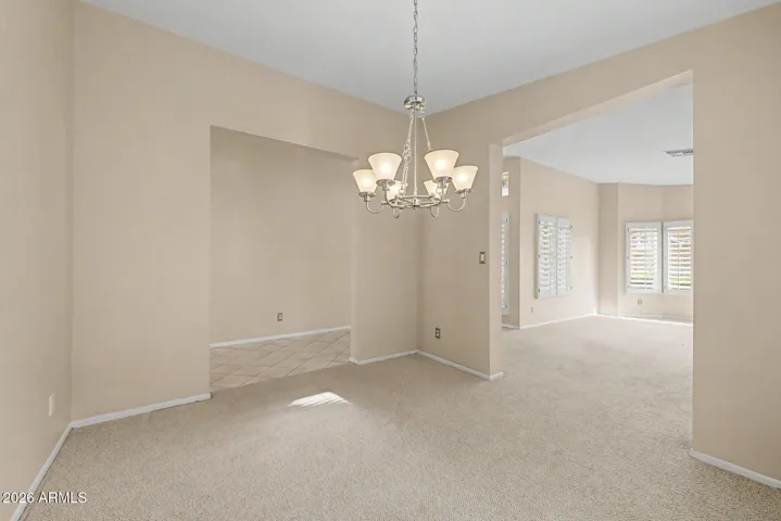 Dining room with overhead chandelier, natural light, and open access to adjacent living areas for easy entertaining.