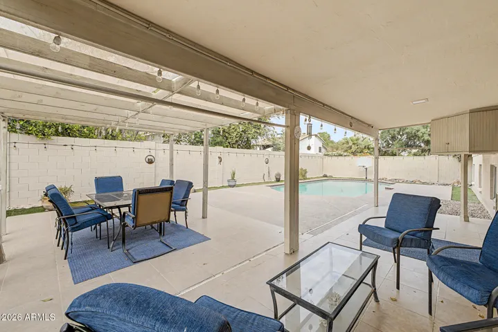 Covered patio seating area providing shaded outdoor living space with open views of the backyard.