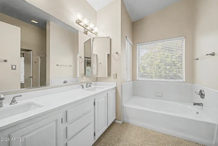 Primary bathroom with dual sinks, large vanity, soaking tub, and separate shower for everyday comfort and functionality.