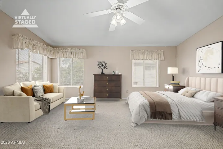 Spacious primary bedroom with large windows, natural light, and comfortable layout overlooking the backyard and pool area.