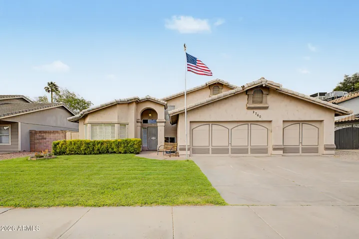 Front elevation highlighting the three-car garage, manicured lawn, and clean exterior lines.