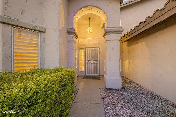 Covered front entry with arched architectural detail creating a warm and inviting entrance.