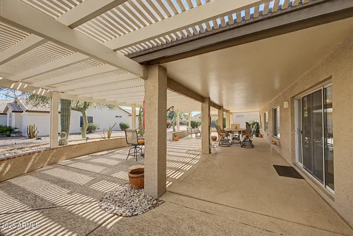 Patio with pergola extending the length of the home