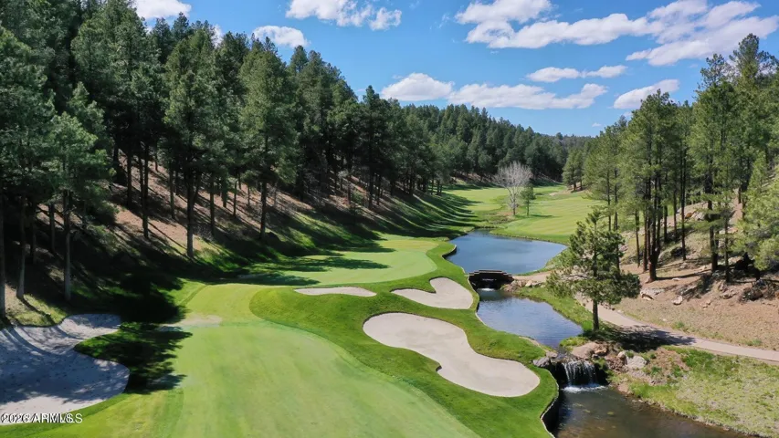 Incredible golf course views with rolling fairways, water features, bridges, and towering pine trees creating a resort-style setting in Flagstaff.