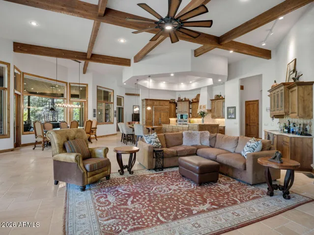 Beautiful great room with soaring ceilings, exposed timber beams, oversized fan, and open living spaces designed for luxury mountain living and entertaining in Flagstaff.