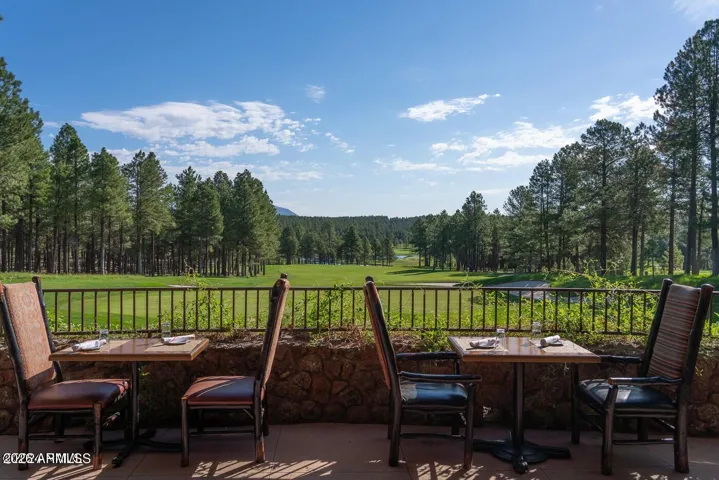 Relaxing outdoor dining area overlooking scenic golf course fairways and mountain views, offering a true luxury lifestyle experience in Flagstaff.