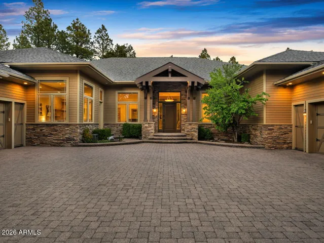 Expansive paver motor court with an impressive 5-car garage, temperature-controlled bays, and generous guest parking designed for luxury mountain living in Flagstaff.