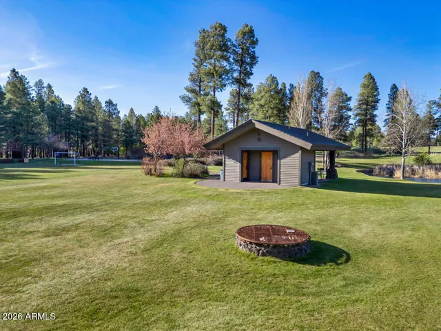 Expansive green space and community sports park within walking distance, surrounded by mature pine trees and scenic open areas in Flagstaff.