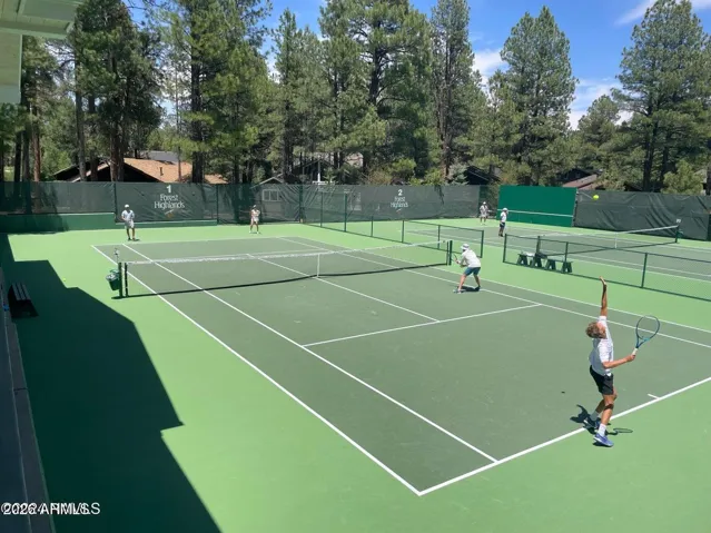 Well-maintained community tennis courts nestled among mature pine trees, offering premier recreational amenities and an active lifestyle in Flagstaff.