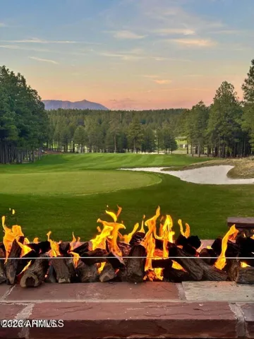 Cozy outdoor firepit area with panoramic golf course and sunset views, perfect for entertaining and enjoying cool Flagstaff evenings.