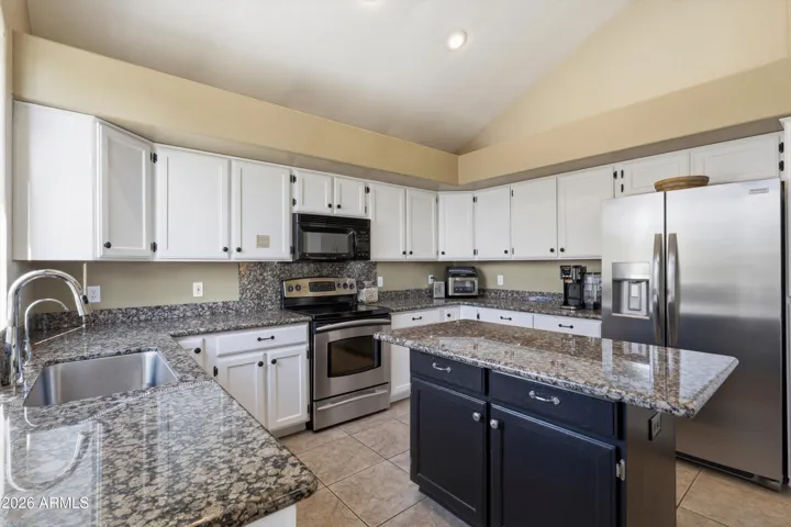 Well appointed kitchen with sink that looks over to pool area below.