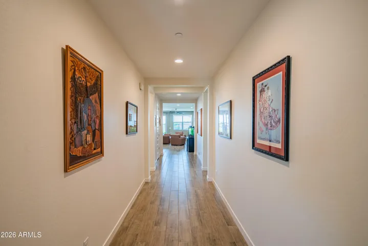 Welcoming hallway with wood-look flooring, neutral tones, and recessed lighting. Clean lines and modern finishes create a bright and inviting entry into the home.