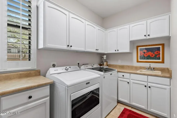 Separate laundry room fully equipped with built-in sink, washer and dryer included and tons of cabinets for storage.
