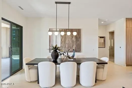 The dining area is ideally positioned across from the kitchen and features a dual-panel glass slider that opens directly to the covered patio, perfect for effortless entertaining.