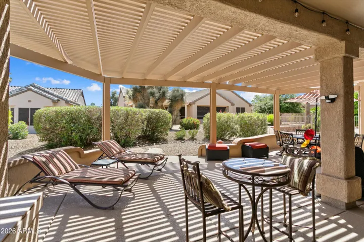 The patio has a bar be que island, knee wall and is covered