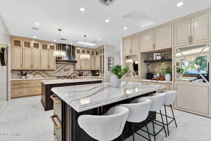 Marble topped islands feature a custom cove ogee edge and custom cabinetry.