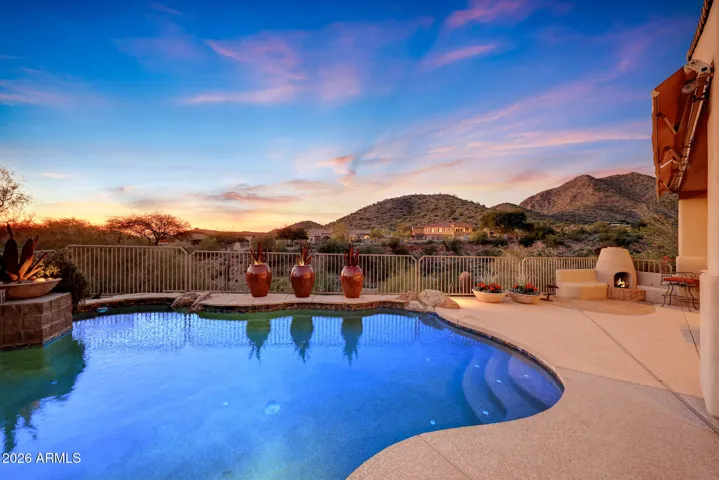 Relax outdoors with a sparkling PebbleTec pool and fireplace