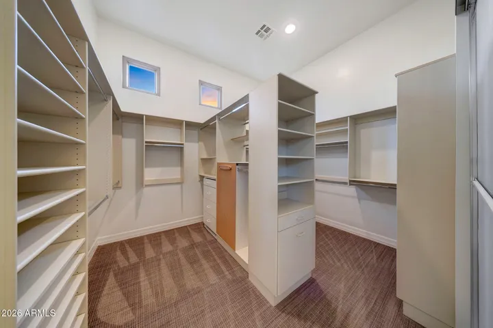 Enjoy a large his and hers walk-in closet with custom built-ins