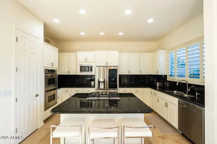 Granite countertops, gas cook top and double ovens, spacious island.