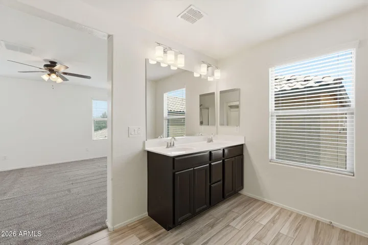 Master Suite with dual sink vanity, walk-in shower, walk-in closet, private commode with door, linen closet