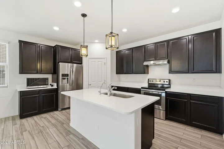 Kitchen features Quartz counters, stainless steel appliances, walk-in pantry, pendant lighting, recessed lighting