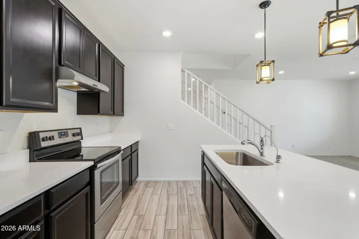 Kitchen features Quartz counters, stainless steel appliances, walk-in pantry, pendant lighting, recessed lighting