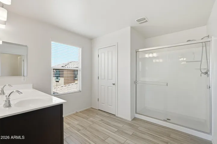 Master Suite with dual sink vanity, walk-in shower, walk-in closet, private commode with door, linen closet