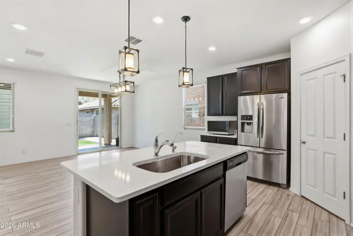 Kitchen features Quartz counters, stainless steel appliances, walk-in pantry, pendant lighting, recessed lighting