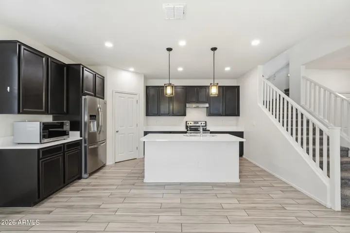 Kitchen features Quartz counters, stainless steel appliances, walk-in pantry, pendant lighting, recessed lighting