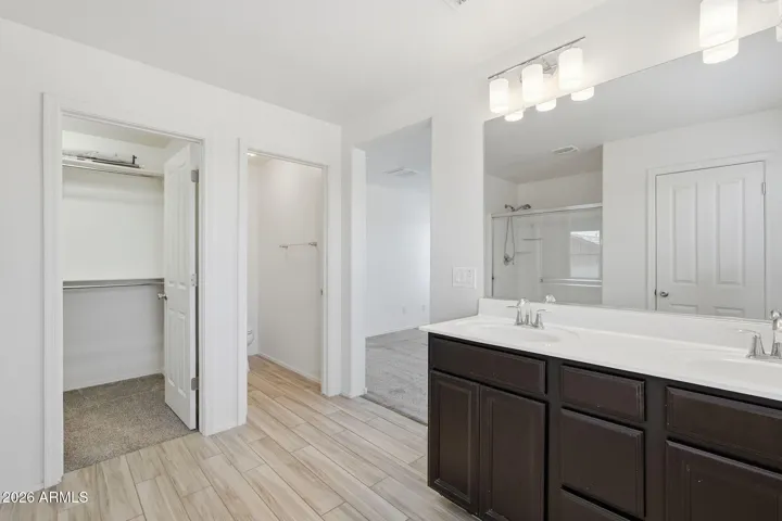 Master Suite with dual sink vanity, walk-in shower, walk-in closet, private commode with door, linen closet