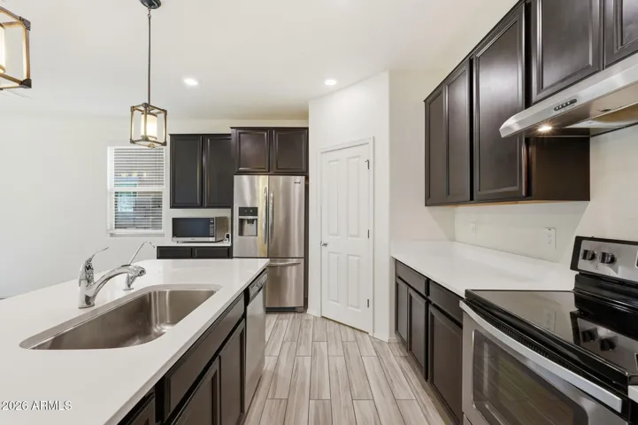Kitchen features Quartz counters, stainless steel appliances, walk-in pantry, pendant lighting, recessed lighting