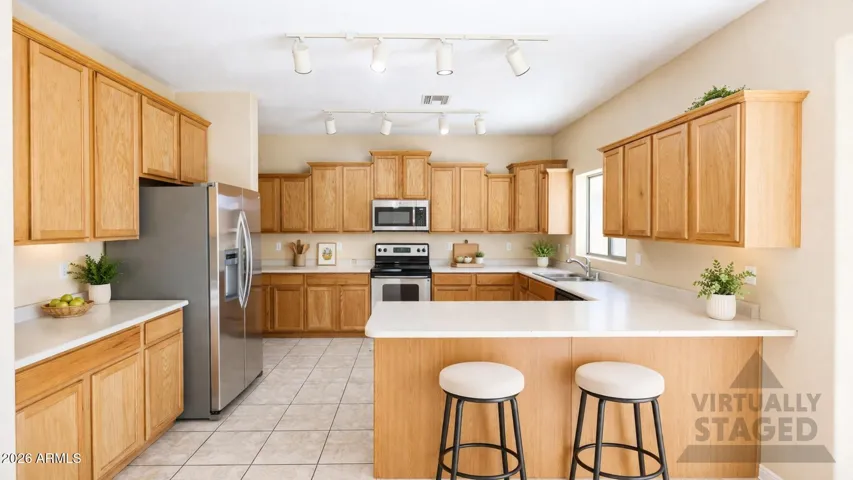Kitchen with stainless steel appliances, breakfast bar and and abundance of cabinetry.
