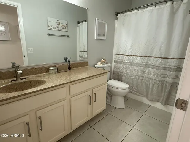 Spacious primary bathroom featuring a large vanity with extended countertop, ample storage, and a clean, functional layout with tub/shower combination.