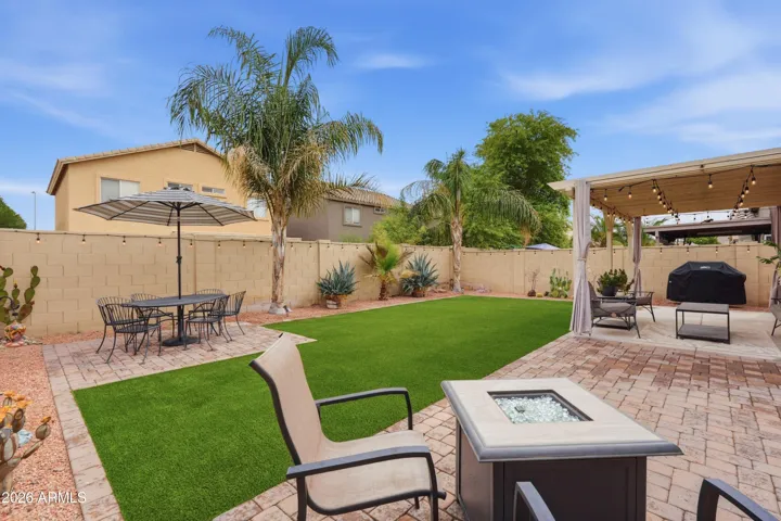 Beautifully designed backyard with low-maintenance landscaping, artificial turf, and mature trees creating a private outdoor retreat.